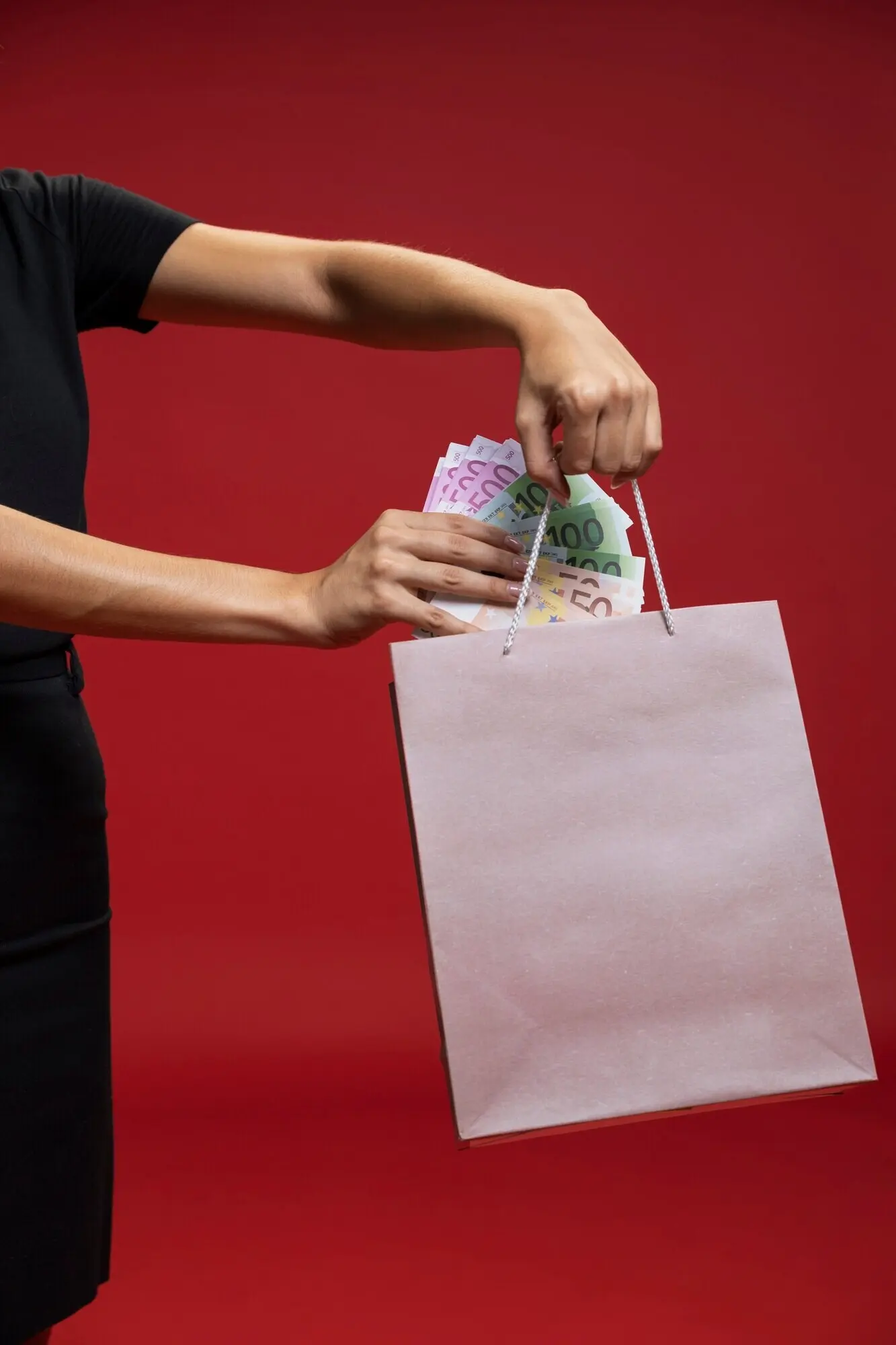 Eine Frau steckt Geld in ihre Einkaufstasche.